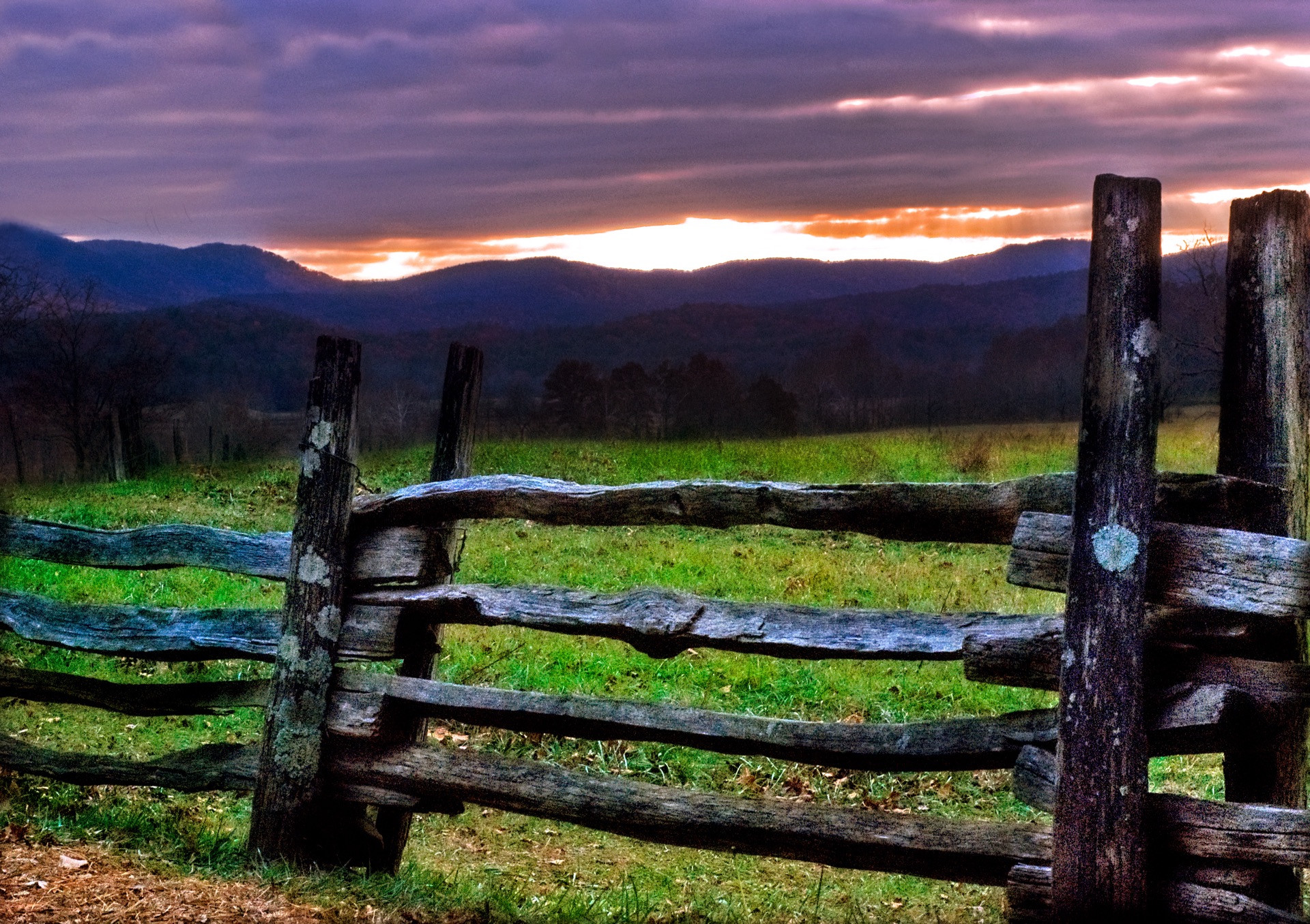 Cades Cove at dusk — split-rail fence, open valley, mountains under a plum sky