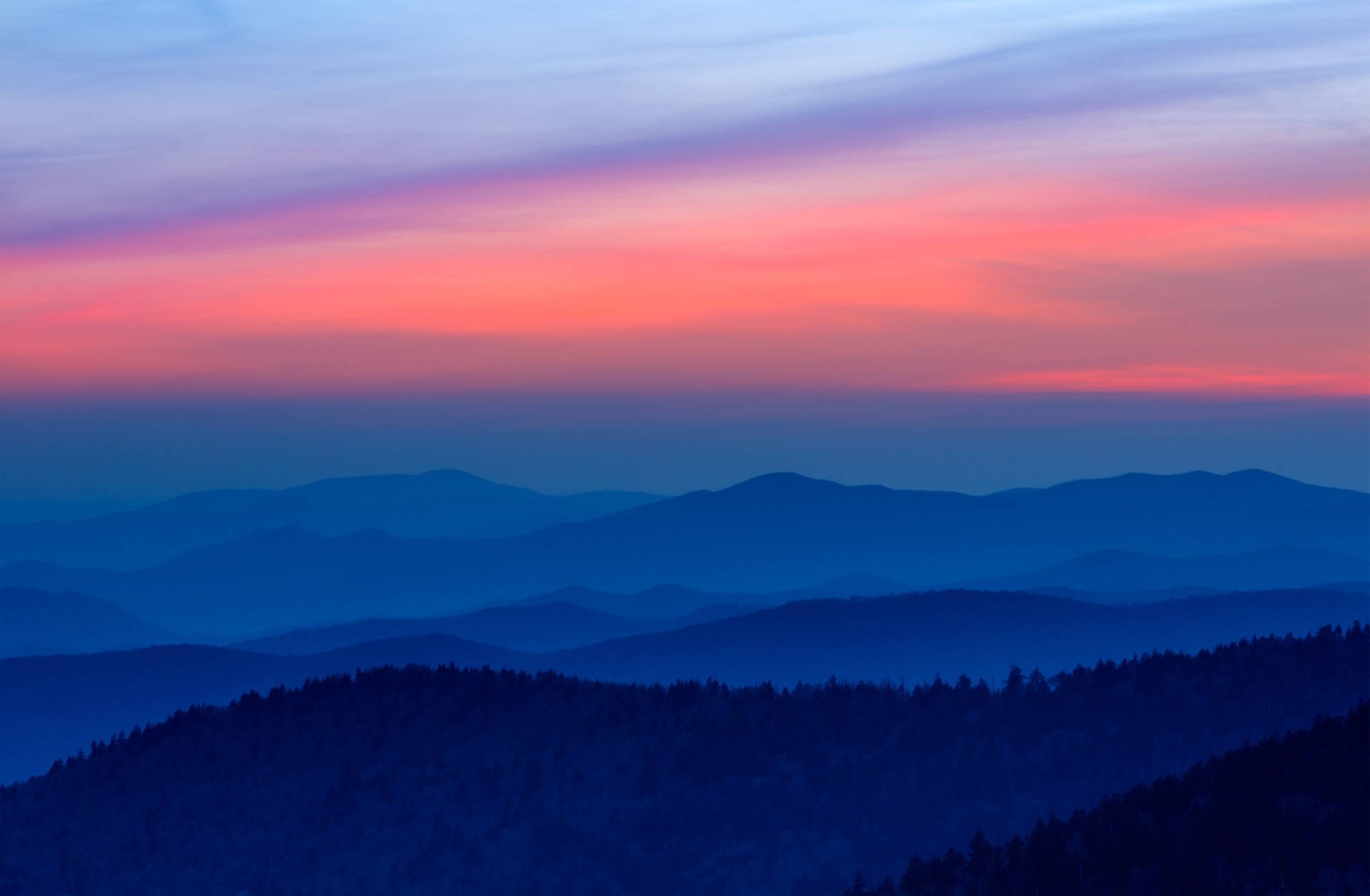 Layered blue ridgelines of the Smokies at dusk under a plum and coral sky